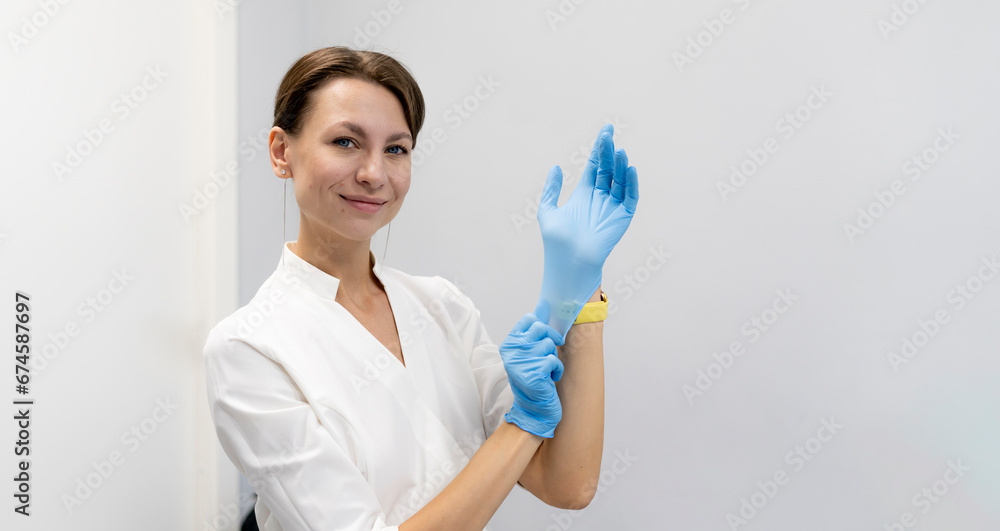 a female dentist puts on blue safety protective gloves a female dentist puts on blue safety protective gloves