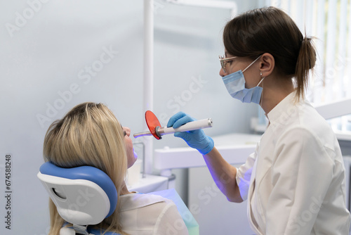 young girl on a teeth whitening treatment  using ultraviolet lamp for bleaching