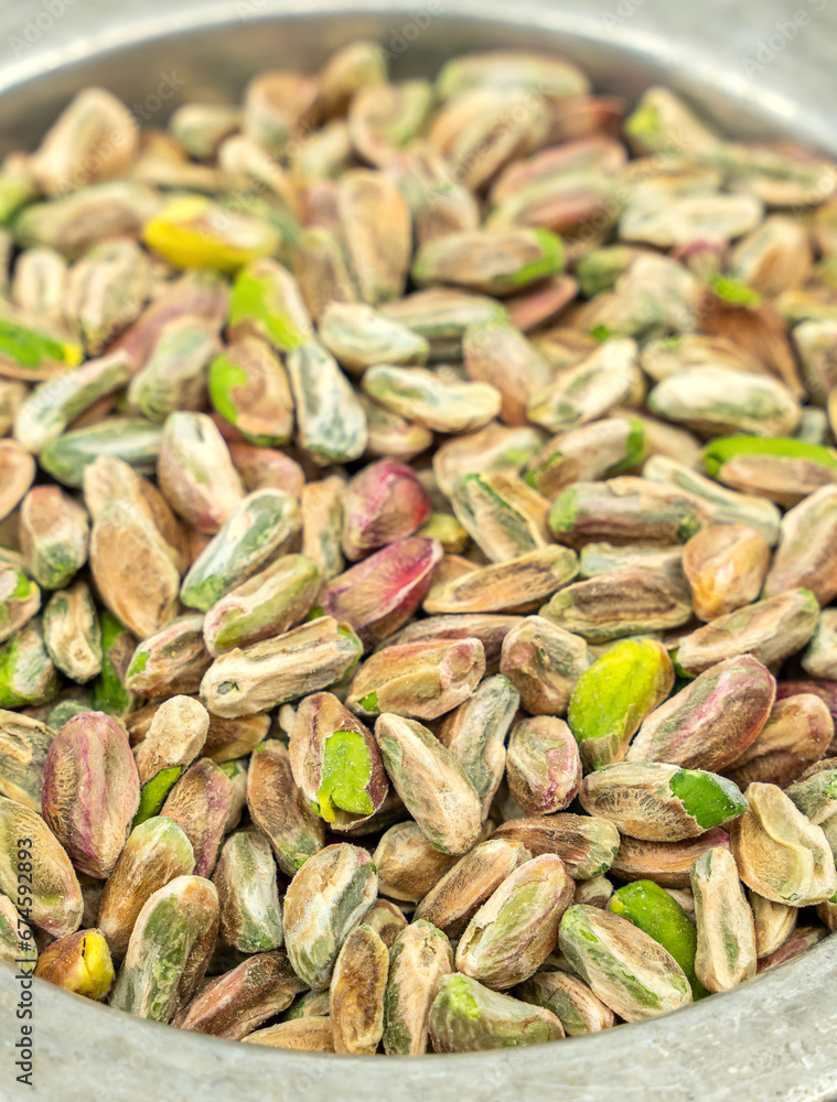 Italian or Turkish Pistachio pile with whole pistachios in the bowl or plate from top on white background Italian or Turkish Pistachio pile with whole pistachios in the bowl or plate from top on white background
