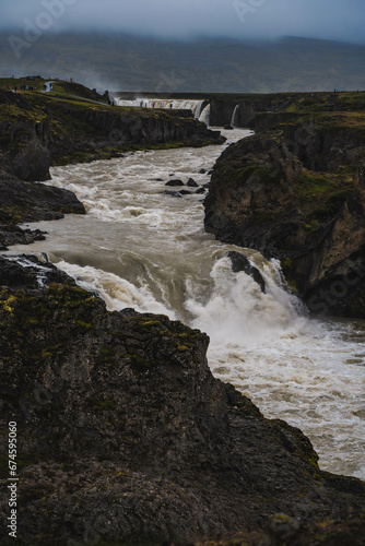 Fast river going down the road. Beautiful view of the waterfall 