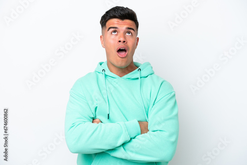 Young caucasian handsome man isolated on white background looking up and with surprised expression © luismolinero