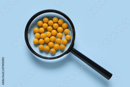 Magnifier with pills on blu...