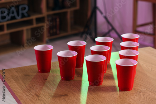 Cups for beer pong on table in room, closeup