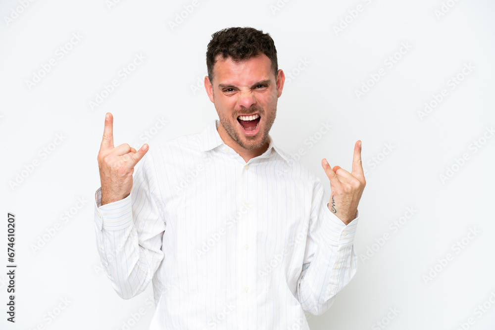 Young caucasian handsome man isolated on white background making horn gesture Young caucasian handsome man isolated on white background making horn gesture