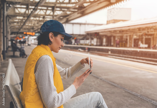 young woman holding passport and tickets, and waiting for train at railway station Enjoying travel concept