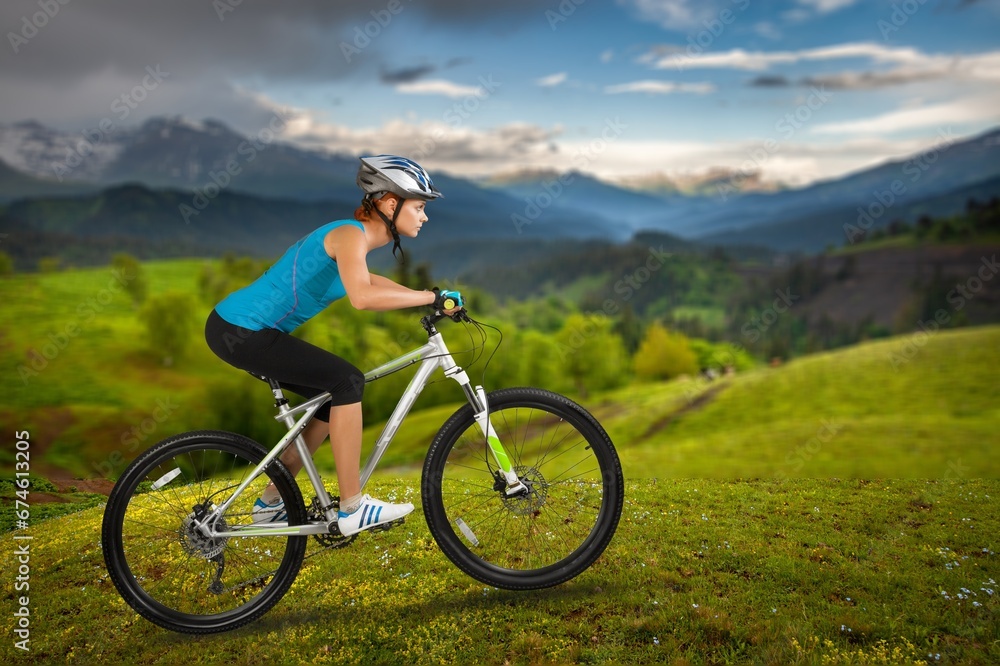 A woman ride on a mountain bike in beautiful nature.