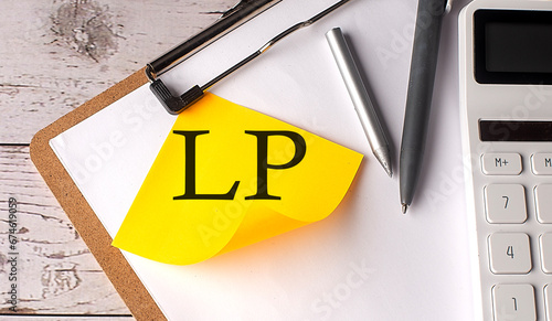 LP word on a yellow sticky with calculator, pen and clipboard photo