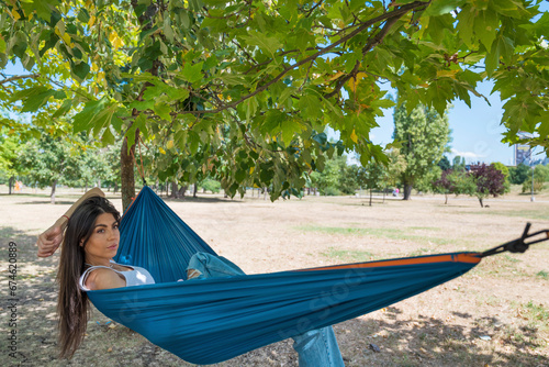 Beautiful young woman relaxing in hammock in the summer 