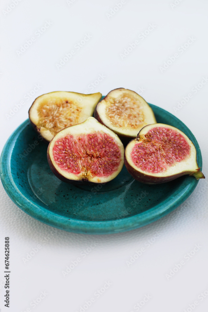 Fig fruits cut on a plate, juicy ripe flesh with seeds Fig fruits cut on a plate, juicy ripe flesh with seeds