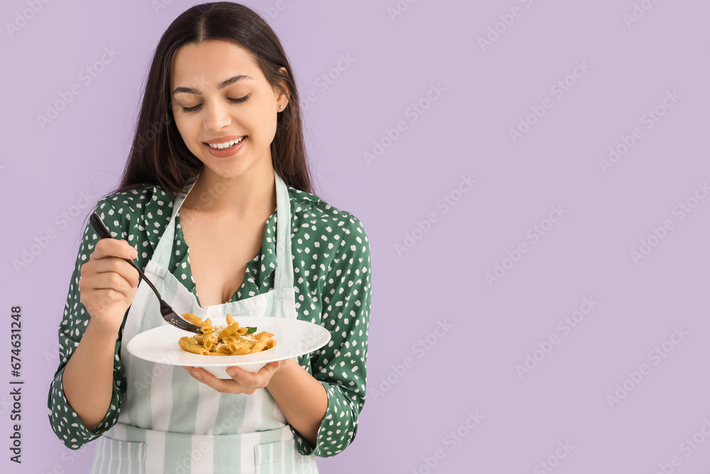 Young woman with tasty pasta on lilac background Young woman with tasty pasta on lilac background