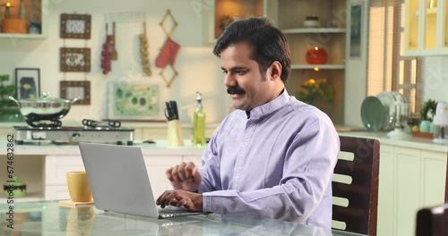 Wallpaper Mural Video of Man Sitting At The Kitchen Table Working From Home On Laptop 
 Torontodigital.ca