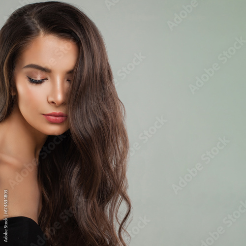Fashion beauty portrait of young perfect female model brunette with long curly hairstyle. Beautiful woman face close up