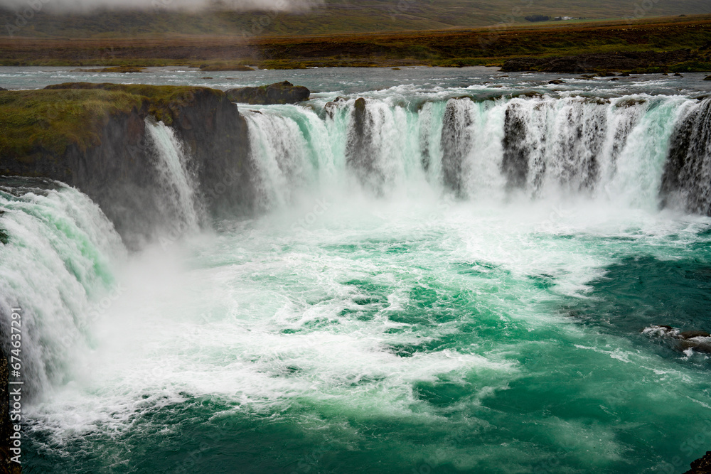 Fototapeta premium A tranquil waterfall cascading into a calm lake.