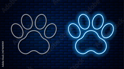 Glowing neon line Paw print icon isolated on brick wall background. Dog or cat paw print. Animal track. Vector