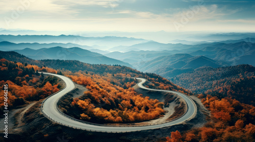 Aerial view of amazing curved road through the mountains during an autumn season.