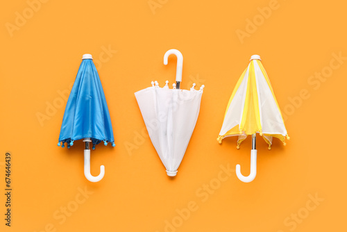 Bild auf Leinwand Mini stylish umbrellas on orange background