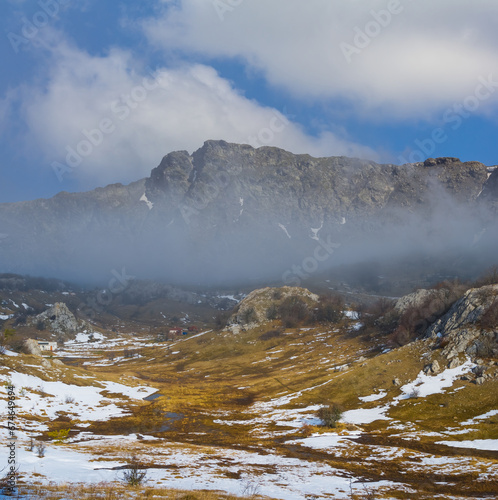 snowbound mountain valley in dense mist and clouds, winter mountain travel scene