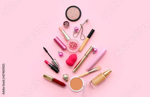 Different decorative cosmetics and Christmas balls on pink background