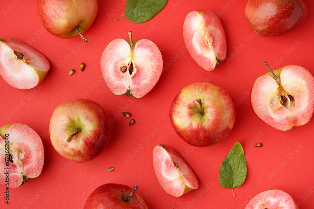 Sweet pink apples and seeds on red background