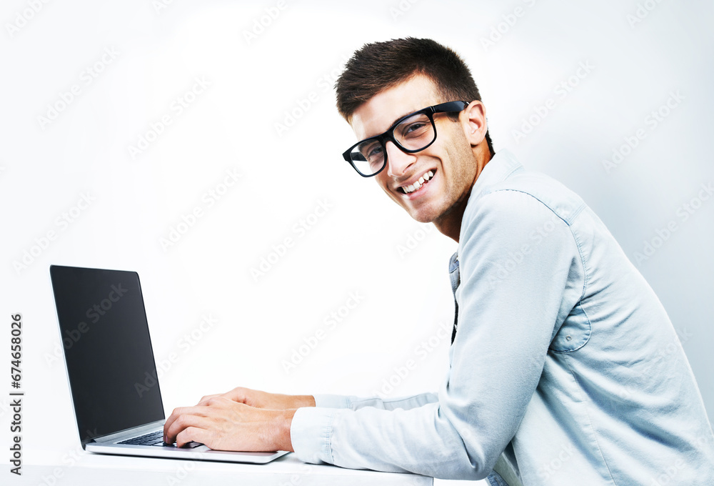 Portrait, business man typing on laptop at table and isolated on white background. Face, smile and geek at desk on computer, technology and IT programmer in glasses, coding and mockup space in Canada Portrait, business man typing on laptop at table and isolated on white background. Face, smile and geek at desk on computer, technology and IT programmer in glasses, coding and mockup space in Canada