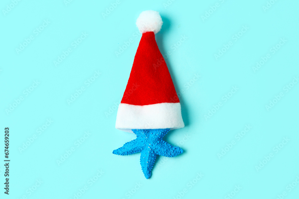 Starfish with Santa hat on blue background Starfish with Santa hat on blue background