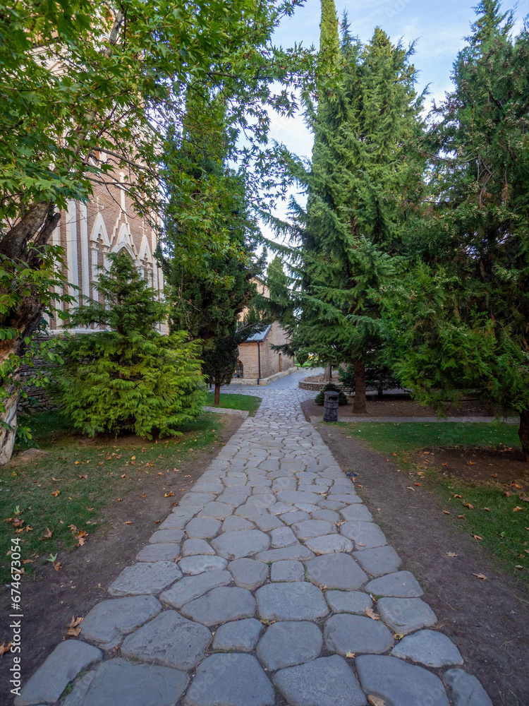 The grey rock curbstone walkway to the church with green pine.