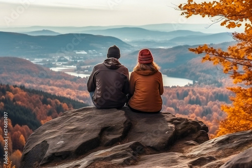 A young couple resting on a rock and enjoying the nature in autumn © Adrian Grosu