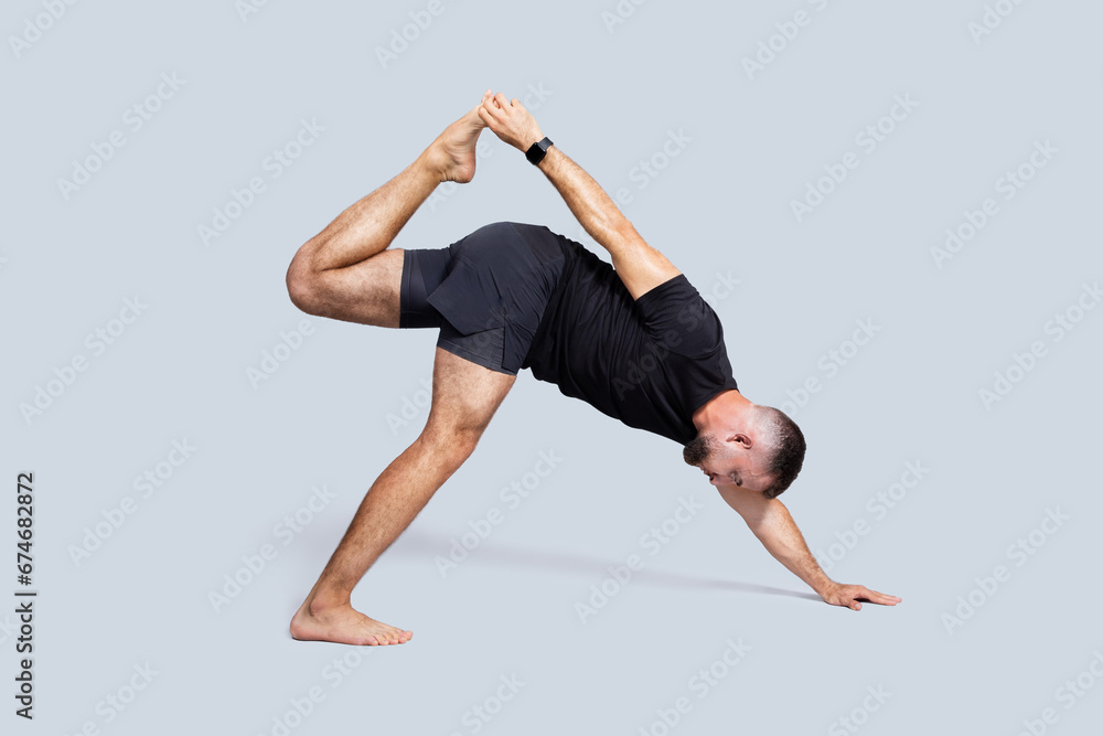 Calm strong millennial caucasian man with beard in sportswear practice yoga, stretching hand Calm strong millennial caucasian man with beard in sportswear practice yoga, stretching hand