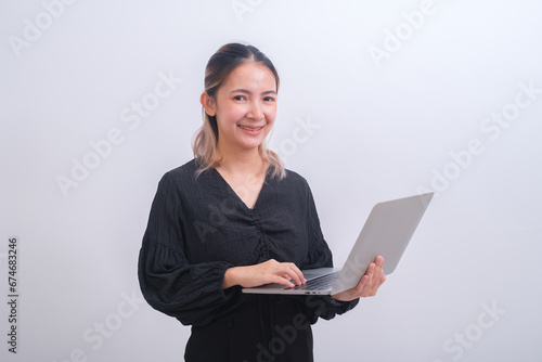 Portrait of young happy business woman holding white screen laptop. Attractive female in smart casual wear holding a computer and present her job or work. Digital tachnology communication concept. photo