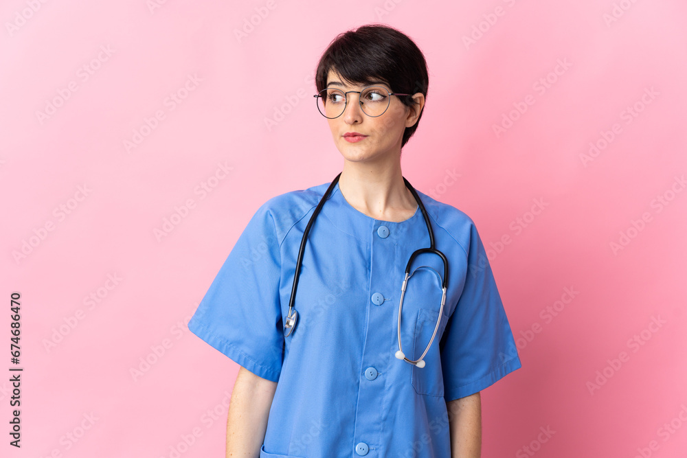 Surgeon isolated on pink background looking to the side Surgeon isolated on pink background looking to the side