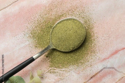 Green powder moringa in the spoon. Concept of nutritional supplement, dieting, detox, preventive healthcare and healthy lifestyle.