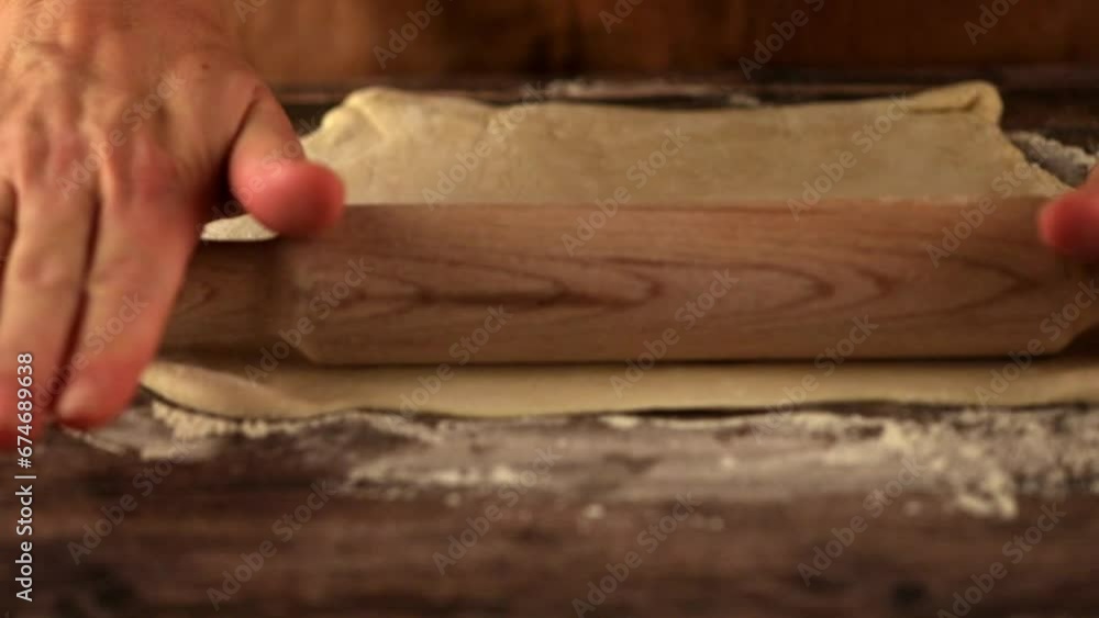 Female hands rolling out dough with a rolling pin Female hands rolling out dough with a rolling pin