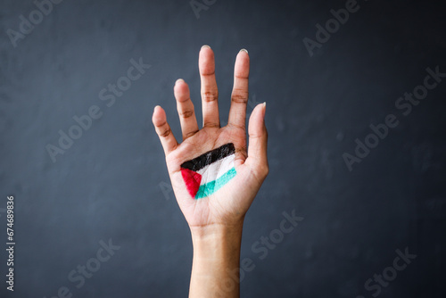 Hand painted with Palestinian flag isolated over dark gray background