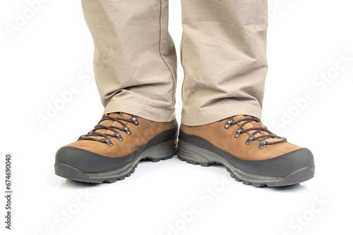 Trekking boots for hiking on the legs of a tourist on a white background. Equipment for travel and hiking