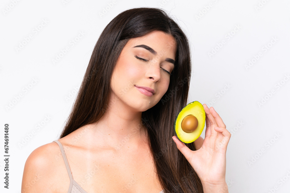 Young Brazilian woman isolated on white background holding an avocado. Close up portrait Young Brazilian woman isolated on white background holding an avocado. Close up portrait