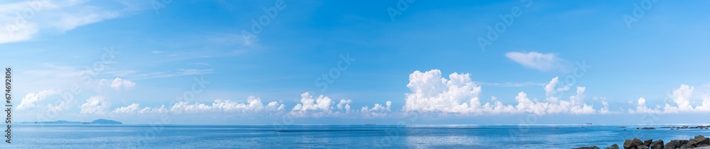 Panoramic blue sky with white fluffy clouds and sea