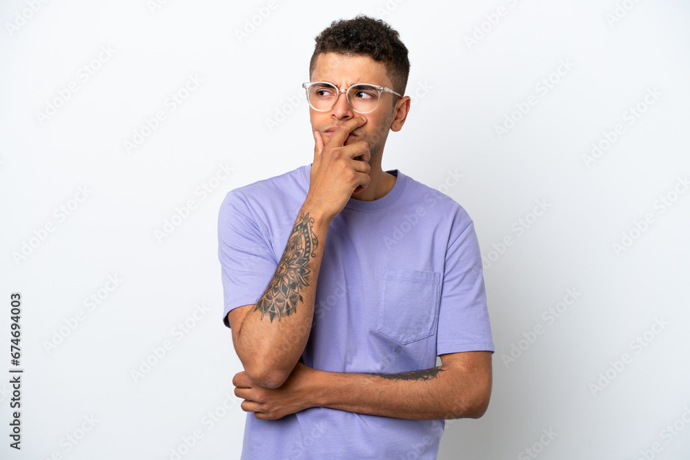Young caucasian Brazilian man isolated on white background having doubts and with confuse face expression Young caucasian Brazilian man isolated on white background having doubts and with confuse face expression