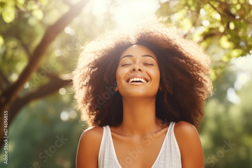 Happy woman surrounded by nature feels world around closes eyes taking deep breath. Smiling woman enjoys freedom feeling happy with closed eyes and taking deep breath against wheat field