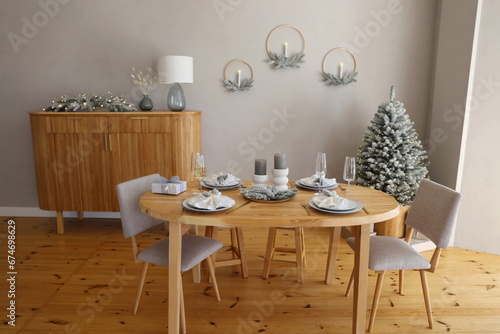 table set for dinner in the apartment decorated for the New Year and Christmas © Tetiana