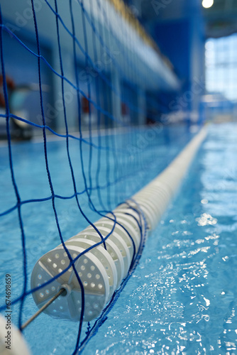 Low part of long gate with net stretching over surface of pure blue water of swimming pool prepared for water polo training or game photo