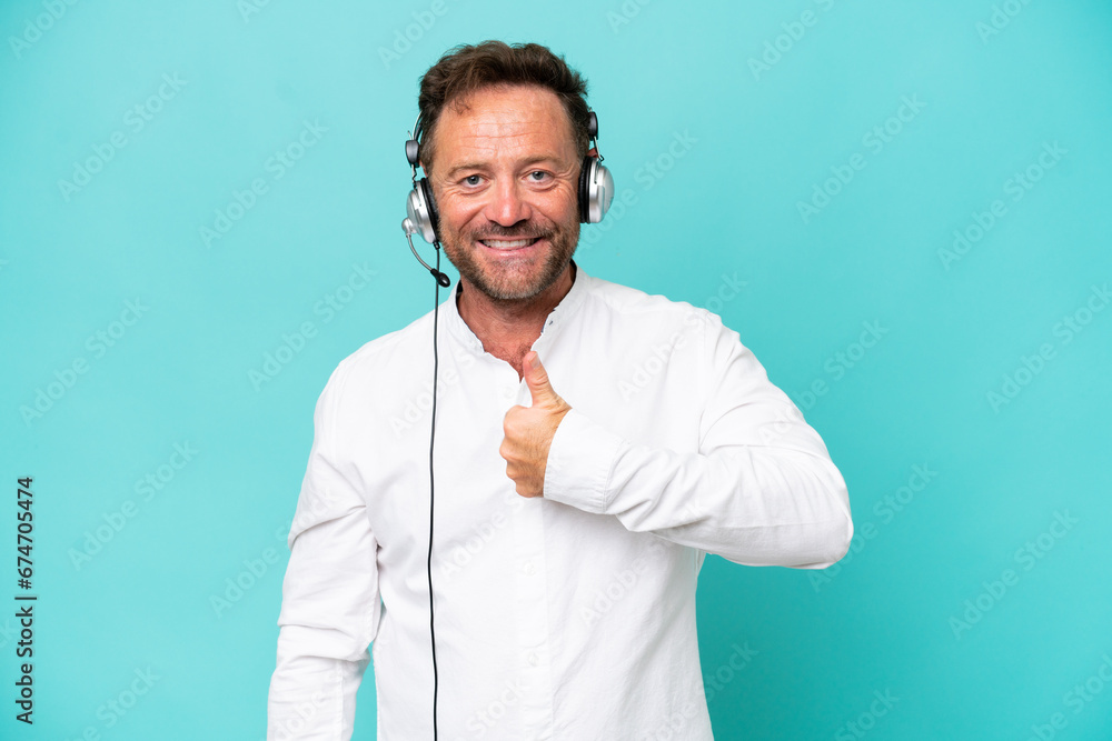 Telemarketer caucasian man working with a headset isolated on blue background giving a thumbs up gesture Telemarketer caucasian man working with a headset isolated on blue background giving a thumbs up gesture