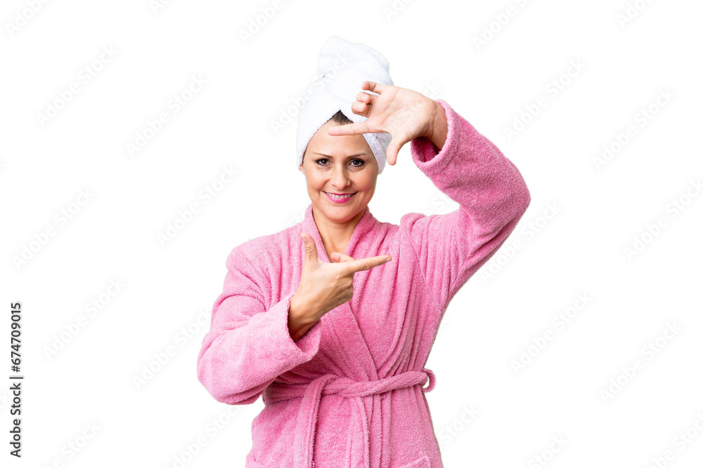 Middle age caucasian woman in a bathrobe over isolated background focusing face. Framing symbol Middle age caucasian woman in a bathrobe over isolated background focusing face. Framing symbol