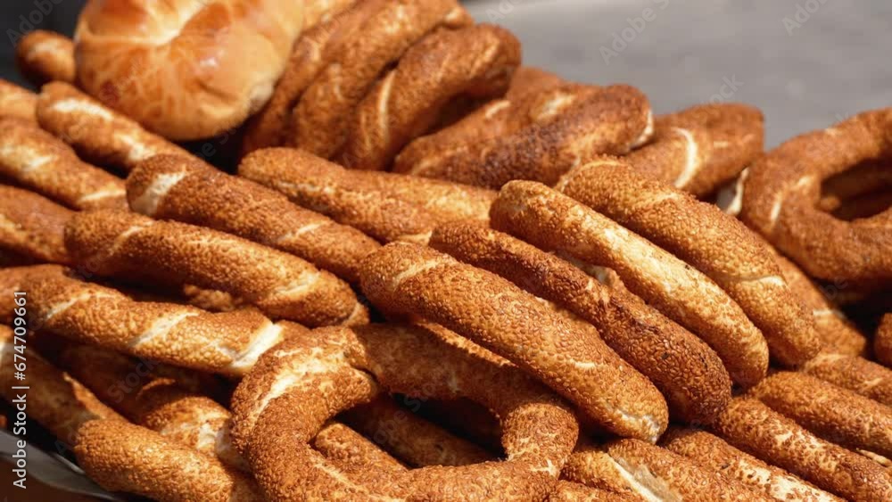Heap of Turkish simits. Fresh simit on street. Turkish sesame bagels. Popular Turkish street food simit. Simit background, side view Heap of Turkish simits. Fresh simit on street. Turkish sesame bagels. Popular Turkish street food simit. Simit background, side view