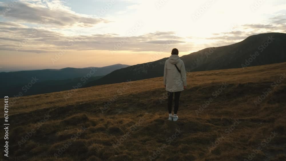 A beautiful Ukrainian young woman traveler walks along the high mountain in Romania Transalpina highway at sunset. Transalpina, Carpathian mountains in Romania at autumn sunrise A beautiful Ukrainian young woman traveler walks along the high mountain in Romania Transalpina highway at sunset. Transalpina, Carpathian mountains in Romania at autumn sunrise