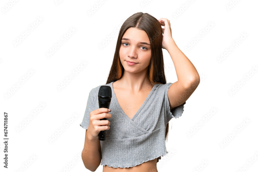 Teenager singer girl picking up a microphone over isolated background having doubts Teenager singer girl picking up a microphone over isolated background having doubts