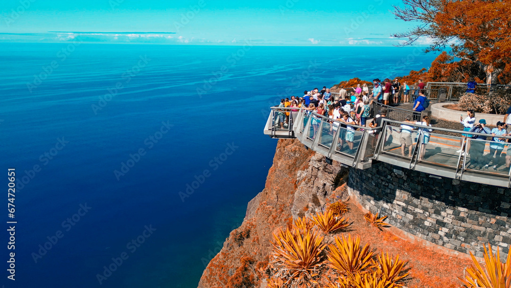 Tourists enjoy the viewpoint at Cabo Girao, along the Madeira coastline, Portugal. Aerial view from drone - obrazy, fototapety, plakaty 