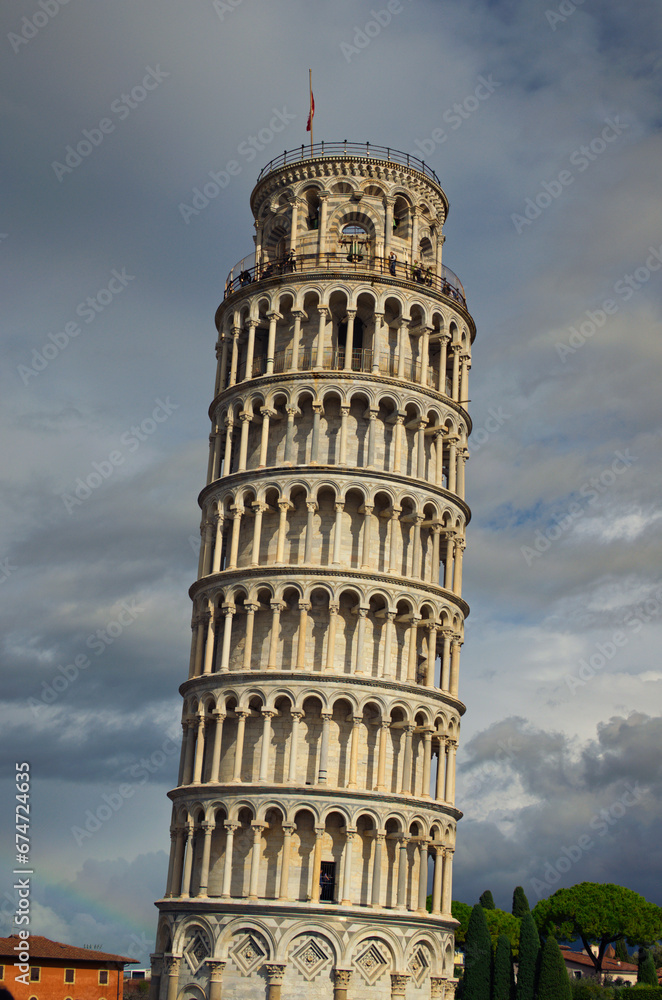 Detailed view of ancient Leaning Tower of Pisa against stormy sky and gloomy clouds. Notable landmark of Pisa, Italy. Travel and tourism concept. UNESCO World Heritage Site