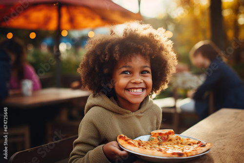Portrait of a smiling African American kid girl eating pizza