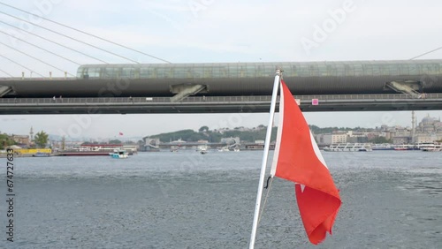 Turkish flag on back of boat in Bosphorus Strait, Istanbul, Turkey Turkish national flag on ship in sea with mountainous shore flies in wind on sunny day on background of city. photo