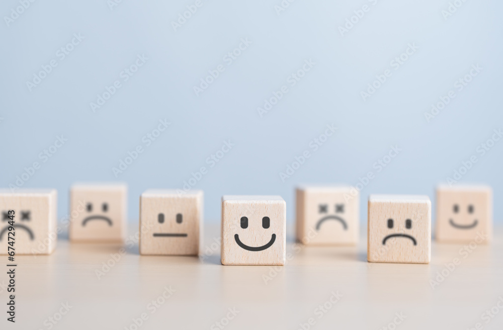 Introvert, Individual person. Unique man is happy and enjoy isolation. Separation or Solitude person. Wooden figure with happy face split line from the crowd. World Mental Health Day, emotion concept. Introvert, Individual person. Unique man is happy and enjoy isolation. Separation or Solitude person. Wooden figure with happy face split line from the crowd. World Mental Health Day, emotion concept.